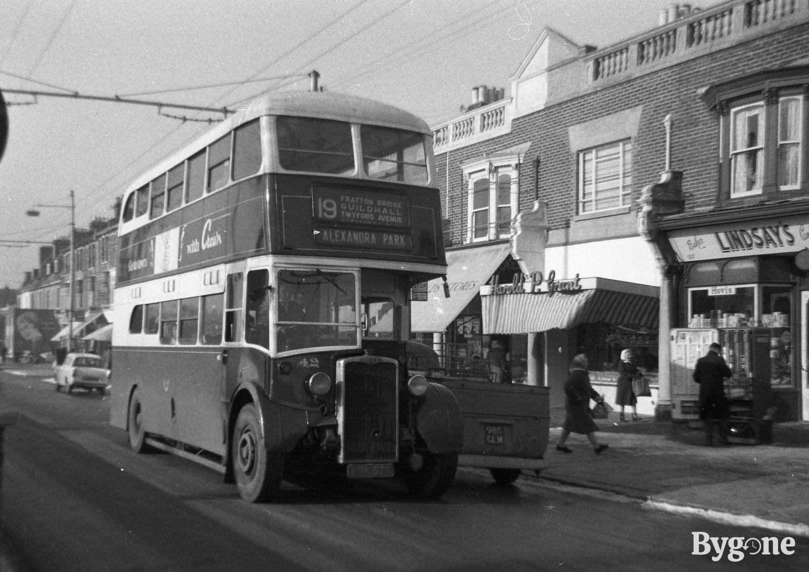 Double decker bus passing by a busy highstreet. It is a number 19 bus, with a sign labelling the stops ‘Fratton Bridge, Guildhall, Twyford Avenue and Alexandra Park’.
