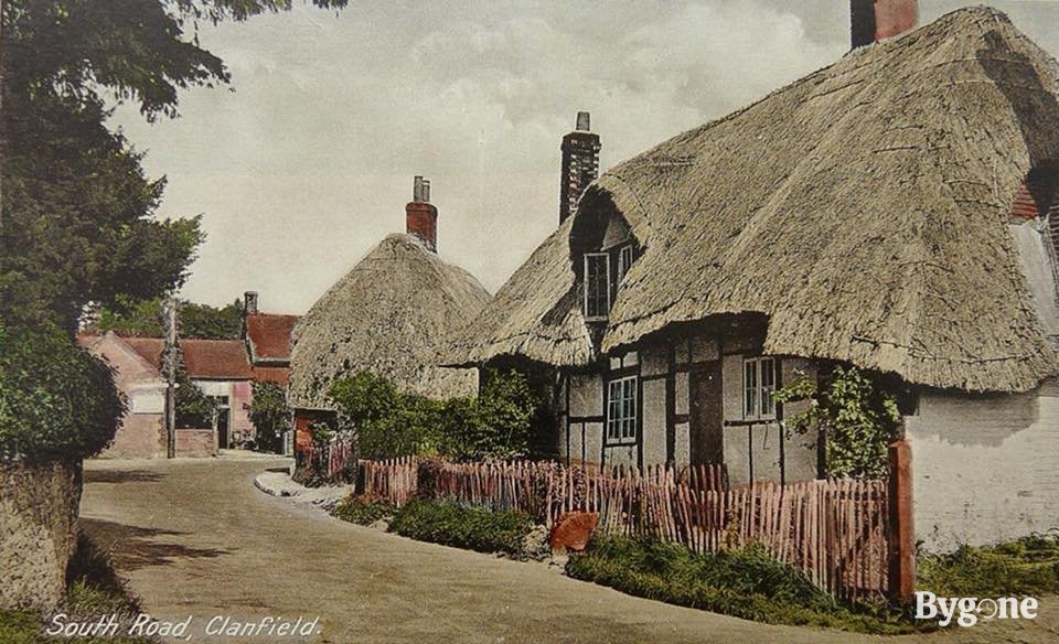 A row of thatched houses winding round a quaint little street.